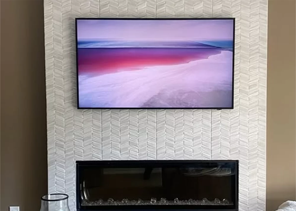 Custom chevron marble fireplace tile installation in Clermont, FL living room by Aesthetic Tile