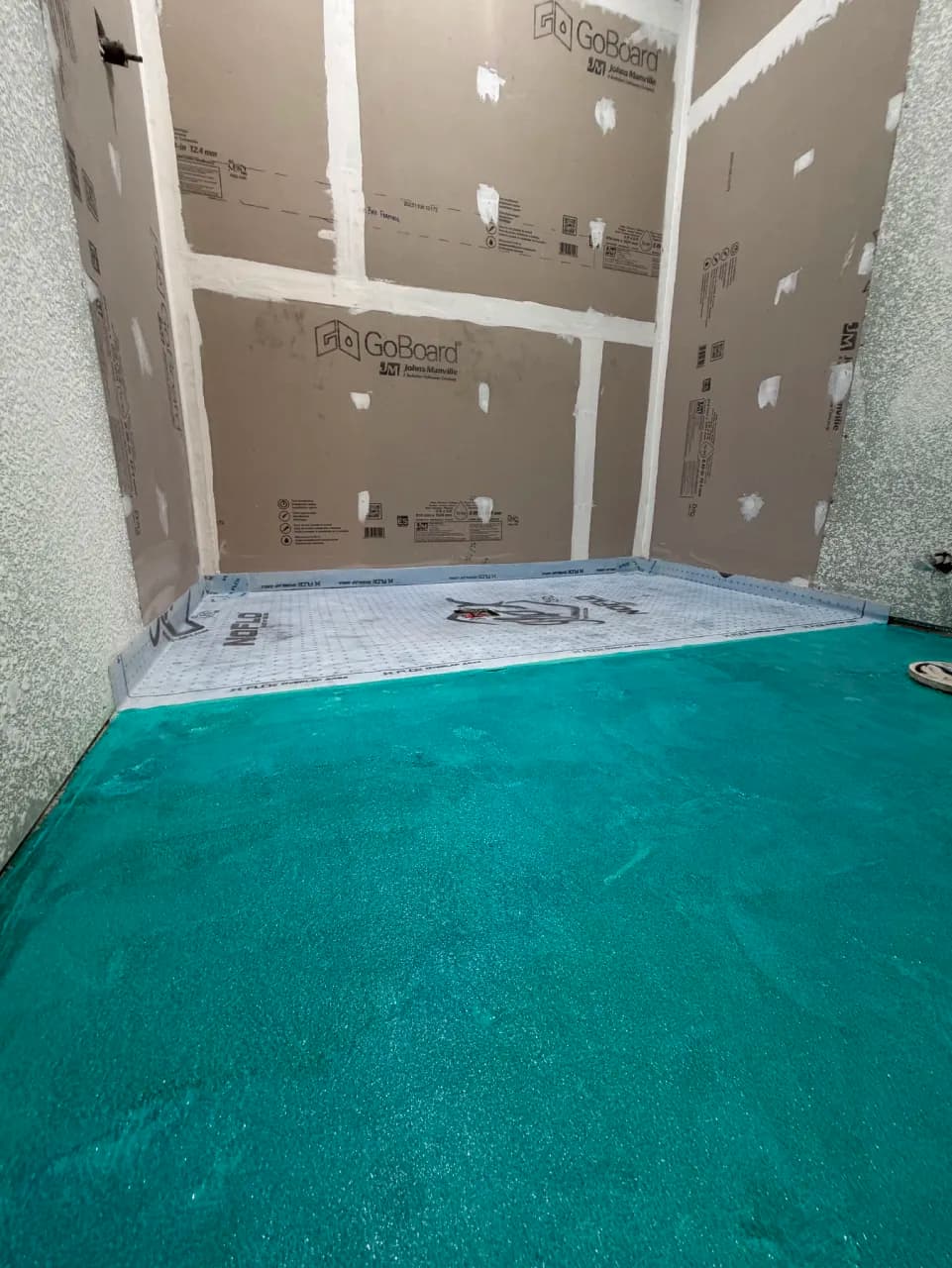 Shower wall boards and prepared floor before tile installation