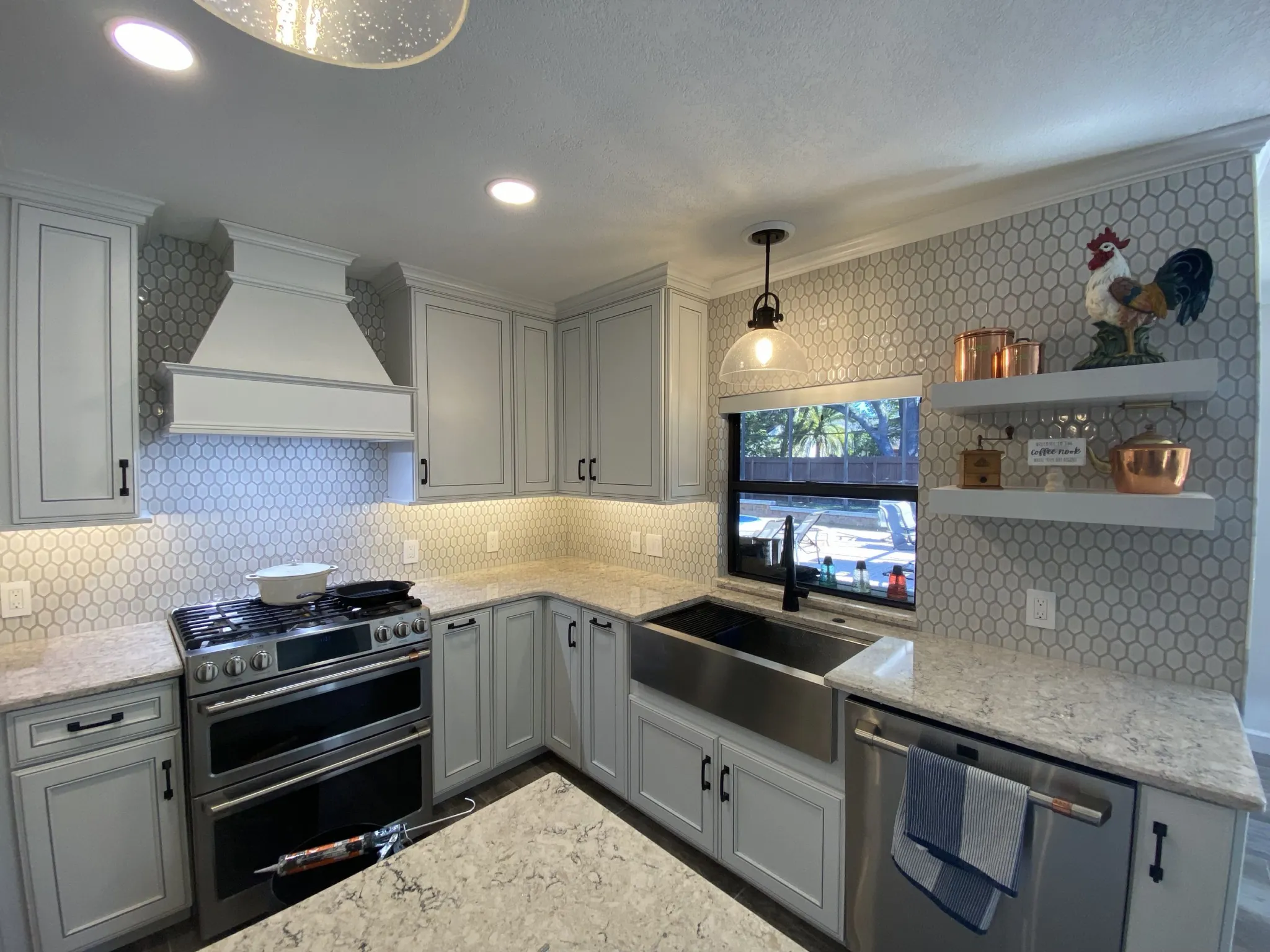 Finished kitchen backsplash extending around the window and range hood
