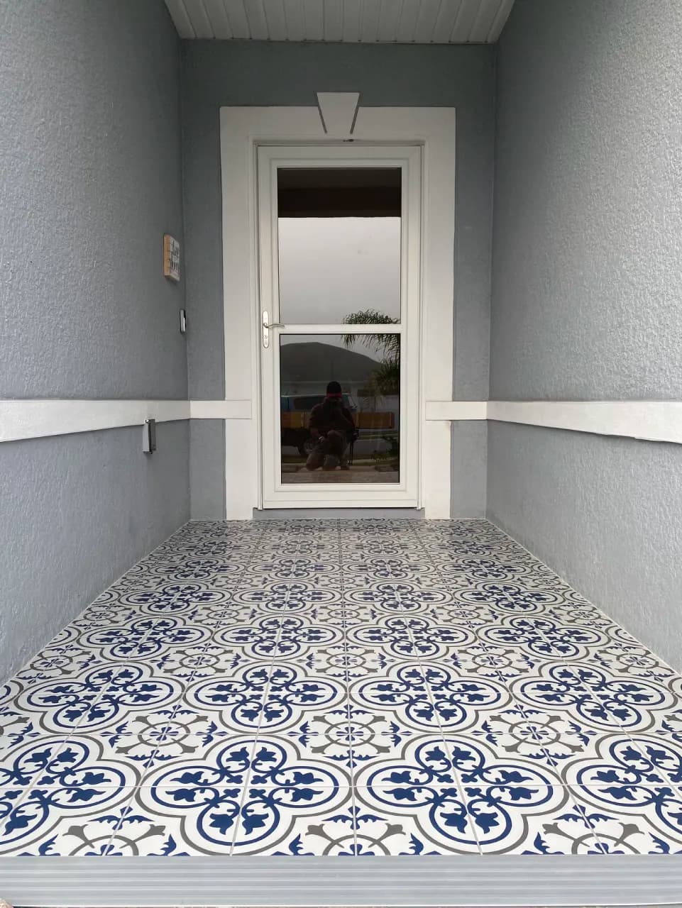 Blue, gray, and white patterned tile across the completed front porch