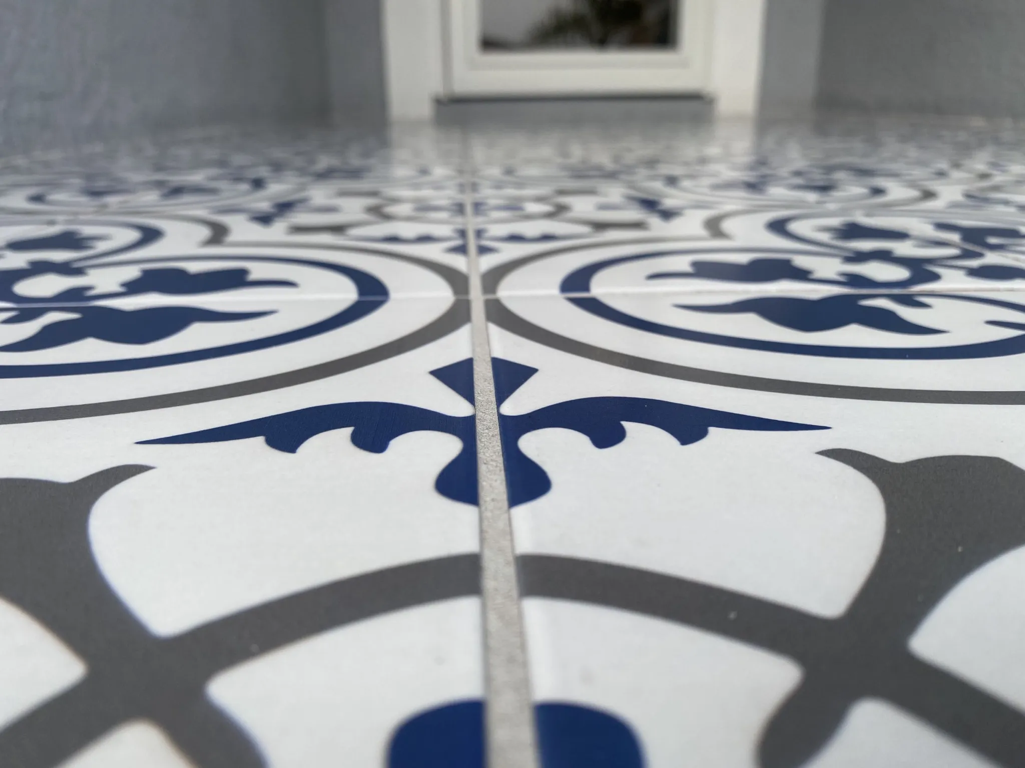 Low view along the decorative porch tile pattern and joints