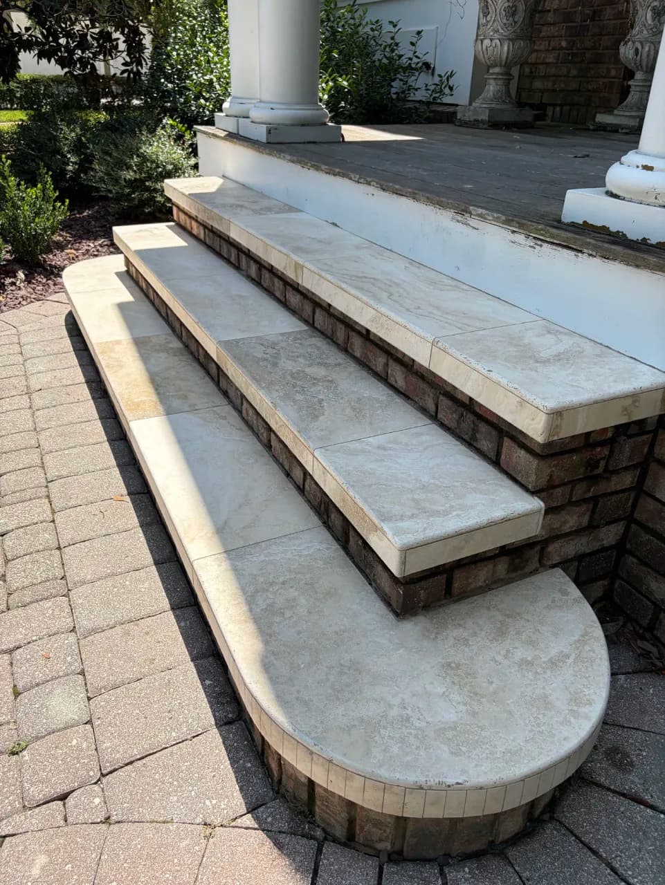 Stone entry steps with rounded edges and a curved lower step