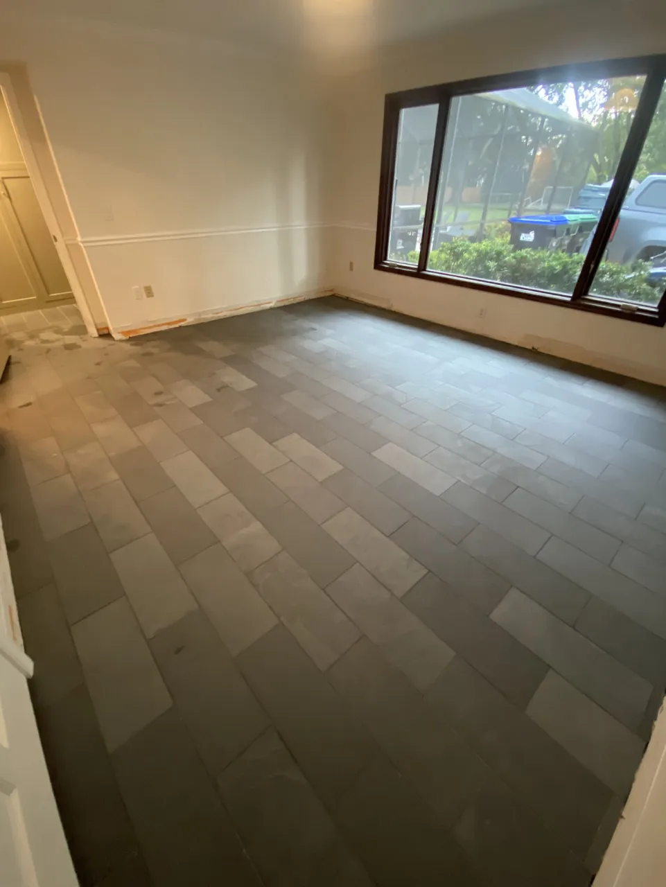 Slate office floor extending across the room below a large window