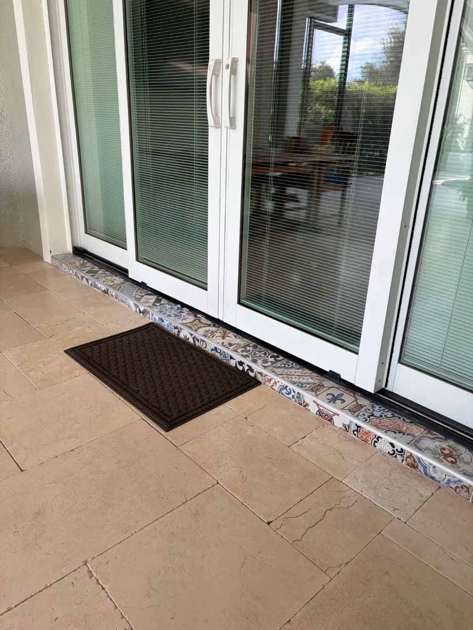 Decorative porcelain tile along the exterior step at sliding doors