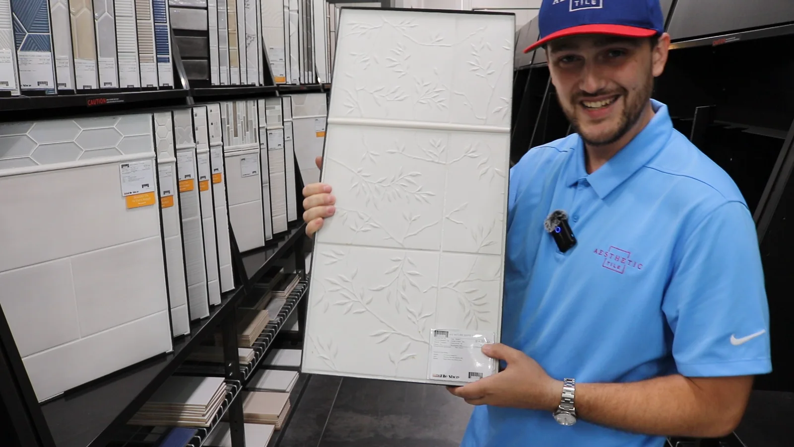 Brad Fleitz of Aesthetic Tile holds a white leaf-relief tile sample in an aisle at The Tile Shop in Orlando, Florida.